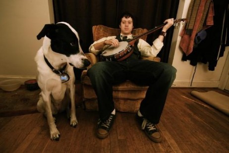 Joel Rakes with a banjo and a dog.